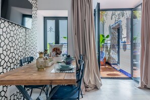 A dining area with a wooden table, chairs, and a view of the outdoor patio. - Dreams of Marbella (Marbella)