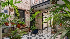 A courtyard with a checkered floor, potted plants, and a stone wall. - Dreams of Marbella (Marbella)