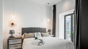 A modern bedroom with a large bed, two bedside tables, a decorative wall piece, and a view of the outdoors. - Dreams of Marbella (Marbella)