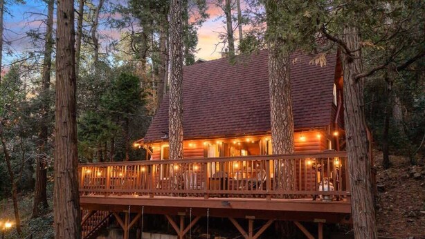 A log cabin with a wooden deck and a staircase leading to the entrance. - Cooled Micro Cabin | 1Bed + Loft (Crestline)