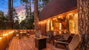 A wooden deck with outdoor seating and a fire pit. - Cooled Micro Cabin | 1Bed + Loft (Crestline)