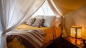 A bed with a canopy, pillows, a blanket, and a bedside lamp. - "Meteor": River View Penthouse in Downtown Mystic (Mystic)