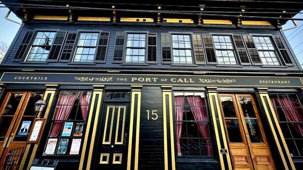 A black building with gold trim and the number 15 on the front. It has signs for 'COCKTAILS' and 'THE PORT OF CALL RESTAURANT'. - "Meteor": River View Penthouse in Downtown Mystic (Mystic)