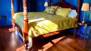 A four-poster bed with a wooden frame and a canopy, a ceiling fan, and two bedside lamps. - "Shepherdess": Mystic Blue Salon With River View (Mystic)