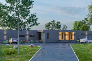 A modern building with a covered entrance, a car parked in front, and a well-maintained lawn. - Wamoon Retreat - The Apartment ~ Luxury Gateway to Wilsons Prom (Yanakie)