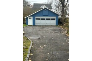 Situated on a paved driveway, this garage offers an entrance to a home.