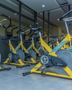 Uma academia com bicicletas ergométricas e equipamentos de ginástica.