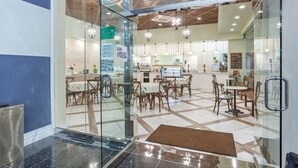 Un interior moderno con comedor, cocina y entrada de vidrio.