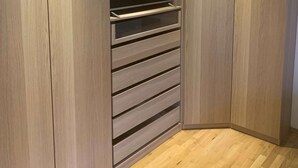 Ein Eckschrank mit Holztüren, einem fest eingebauten Regal und einem Flachbildfernseher.