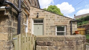 A stone building with a wooden gate, a door, and a window. - 3 Hamilton Terrace (Harrogate)