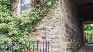 A stone wall with a metal railing, a potted plant, and a bench. - 3 Hamilton Terrace (Harrogate)