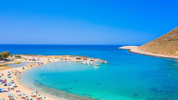 A coastal beach with clear turquoise waters, a sandy shore, and several boats anchored near the beach. - Aelia - Vacation house with private pool in Kounoupidiana, Crete (Kounoupidianá)