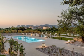 Une piscine avec des chaises longues et une vue sur les montagnes en arrière-plan.