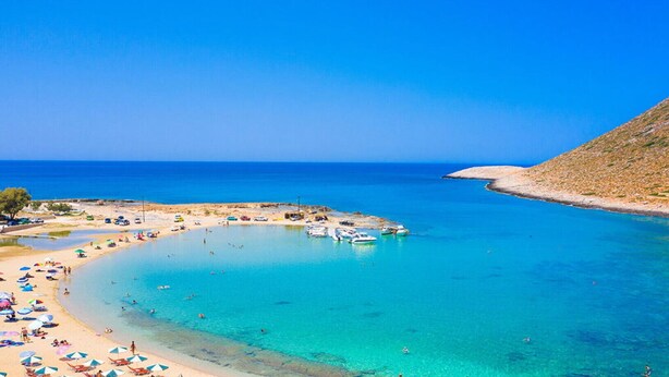A coastal beach with clear turquoise waters, a sandy shore, and boats anchored nearby. - Iris - Vacation house with private pool in Kounoupidiana, Crete (Kampáni)