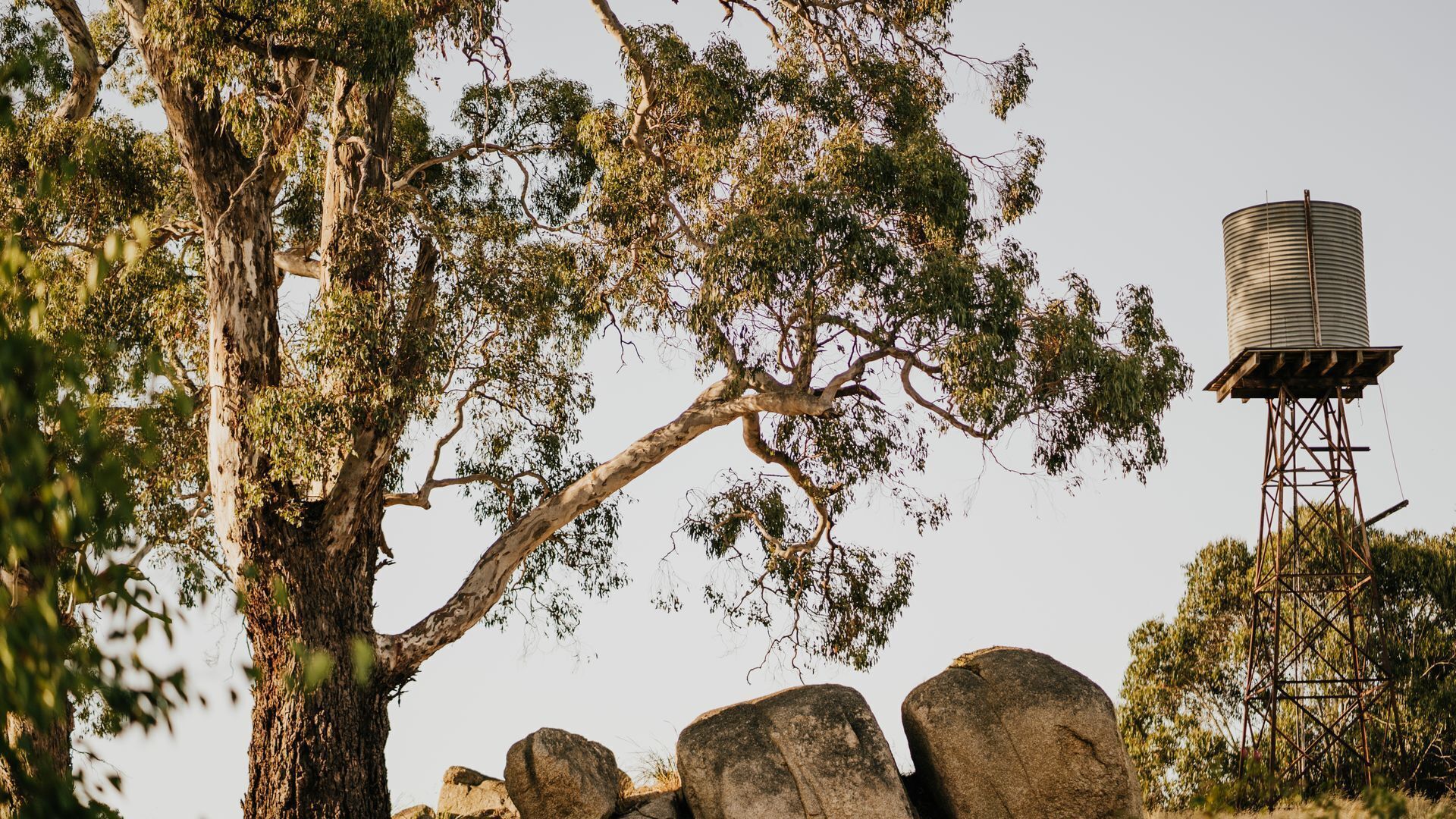 A water tower and large rocks in a natural setting.