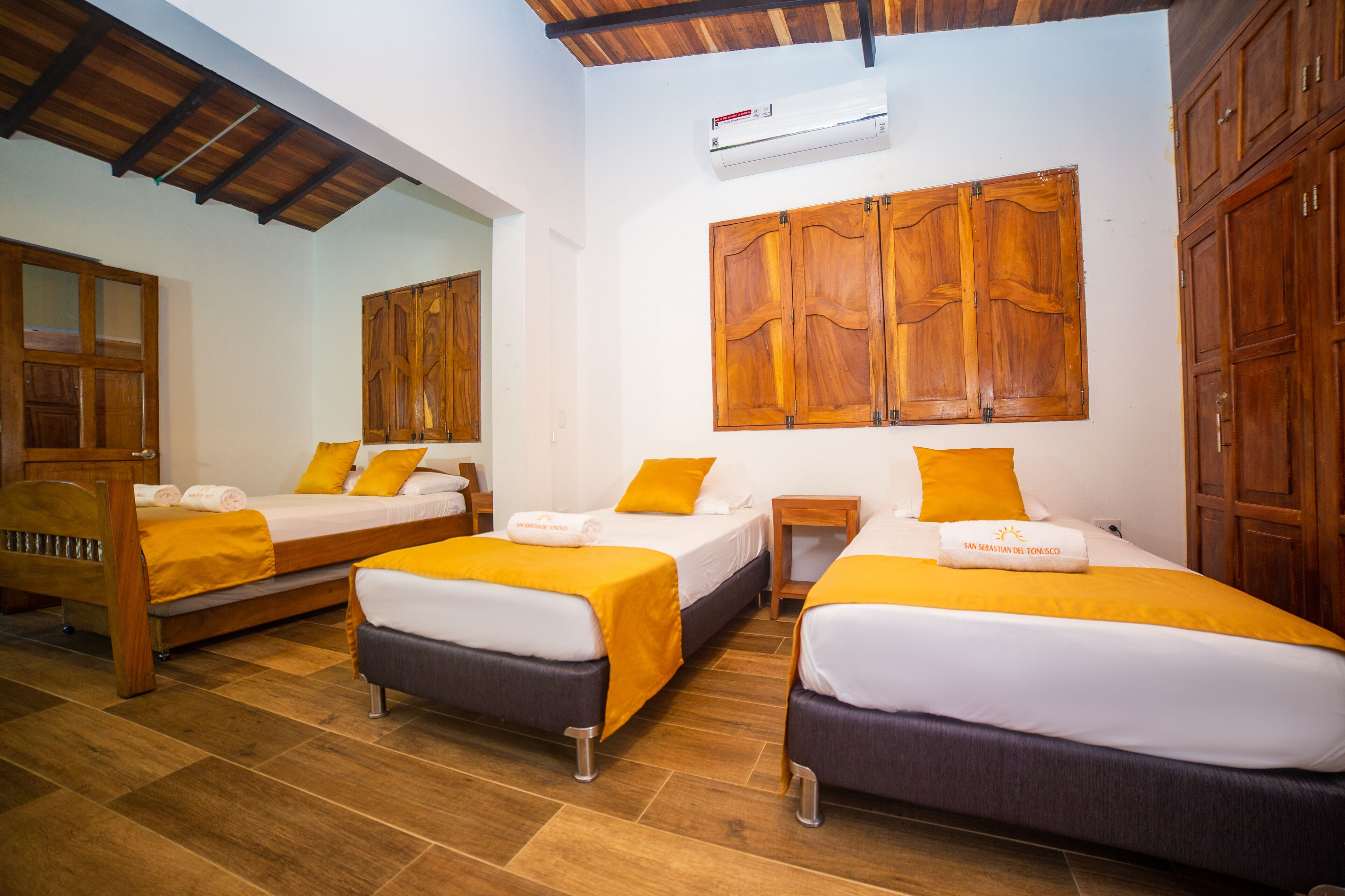 A hotel room with two beds, wooden headboards, and a large wooden cabinet.