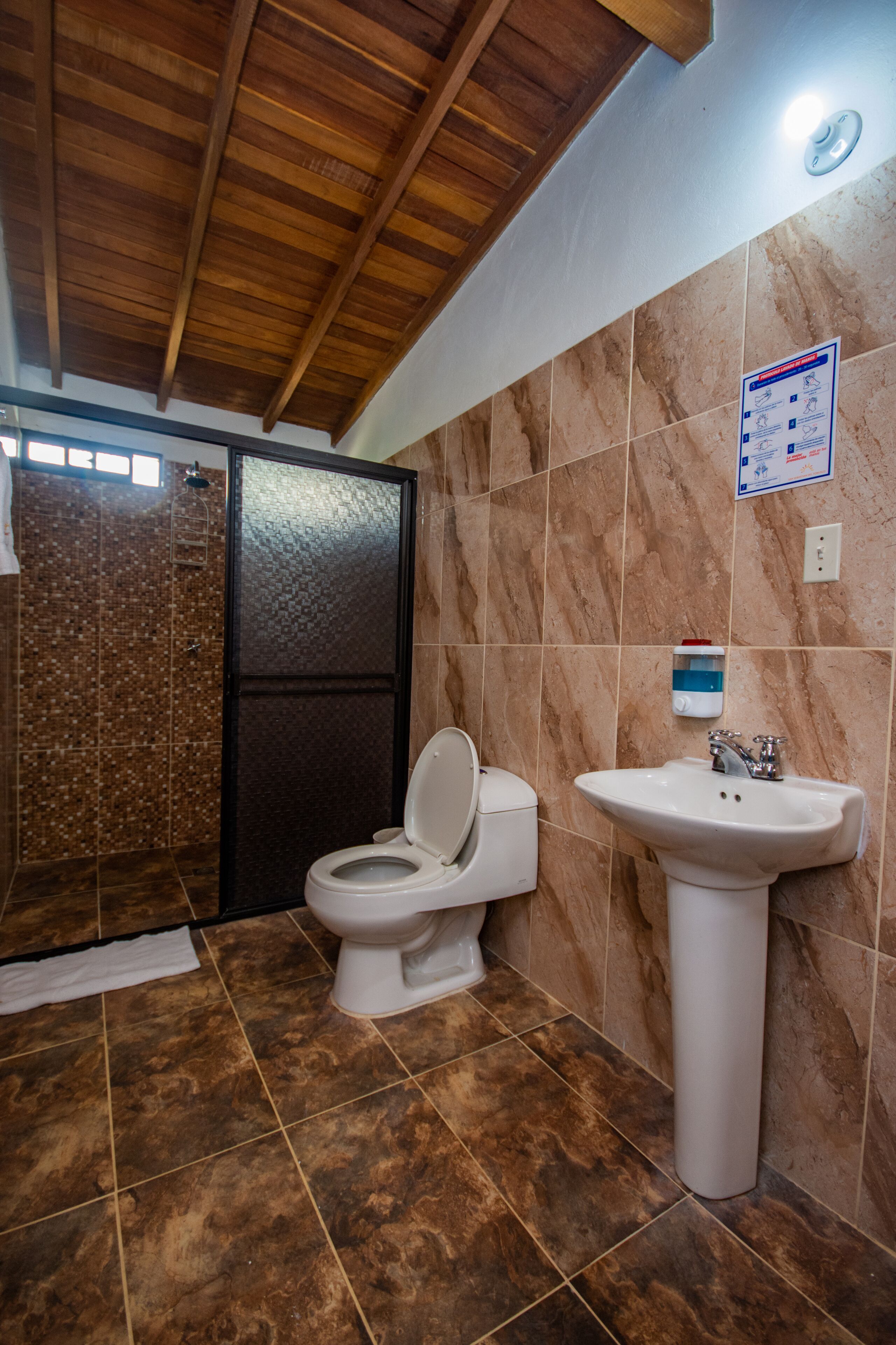 Un baño con ducha, inodoro y lavamanos.