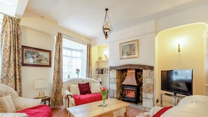 A cozy living room with a fireplace, comfortable seating, and a television. - 3 bedroom accommodation in Colyton, near Lyme Regis (Colyton, near Lyme Regis)