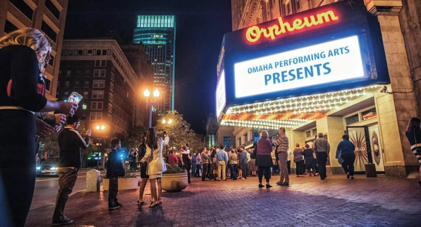 A theater marquee with the word "Orpheum" and a sign indicating "Omaha Performing Arts Presents."