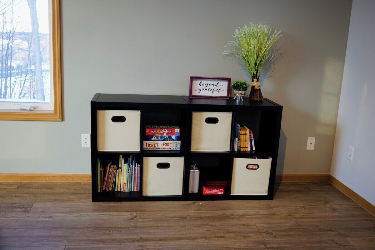 A black storage unit with multiple compartments, including a section with books and another with a ticket box.