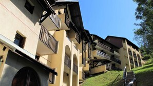 A multi-story building with balconies and a staircase leading up a grassy slope. - 300m from ski slopes, 4th floor, balcony, 23m², Vars (Vars)
