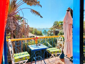 A balcony with a table and chairs, overlooking a coastal view. - Loft Keur Bibou (Dakar)