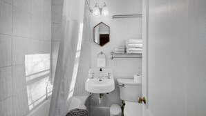 Une salle de bain moderne équipée d’une douche, de toilettes, d’un lavabo et d’un porte-serviettes.
