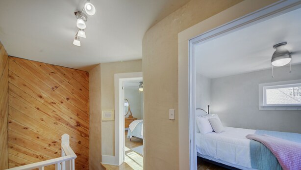 Une chambre à coucher avec un lit, une fenêtre et un luminaire au plafond.
