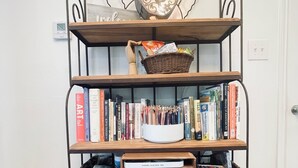 Une bibliothèque à plusieurs étagères, dont certaines sont remplies de livres et d’autres de paniers.