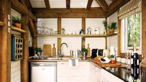 A rustic kitchen with wooden beams, a central island, and various kitchen appliances.