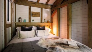A cozy room with a bed, a fur rug, and a sign on the wall.