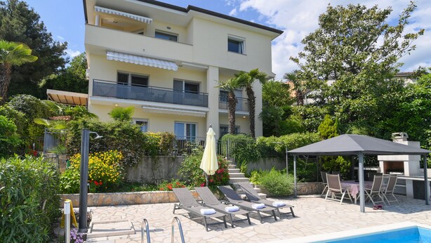 A multi-story building with a pool area, including lounge chairs and a gazebo. - APARTMENTS GROZIC **** OPATIJA - APARTMENT A2 (Opatija)
