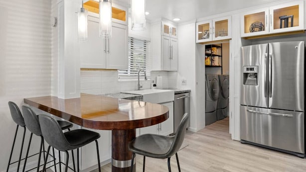 A modern kitchen with a central island, stainless steel appliances, and pendant lighting.