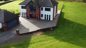 A modern two-story house with a large front porch, a garage, and a well-maintained lawn. - Ty Marlyn (Swansea)