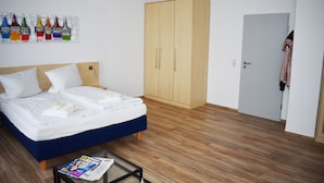 Un dormitorio con cama, armario y revista sobre una mesa.