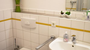 Un baño con inodoro, lavamanos y espejo.