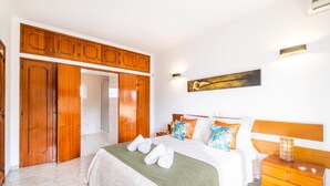 Un dormitorio con cama, armario de madera y mesita de noche.