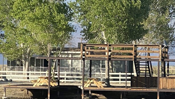 Un muelle de madera que se adentra en el agua, sostenido por una estructura metálica.