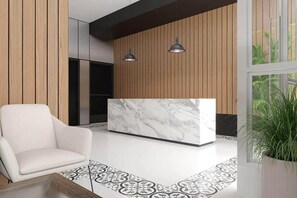 A modern reception area with a marble reception desk, a white chair, and a patterned rug. - Apartment near the sea in Chorrillos a few steps from Barranco (Chorrillos)