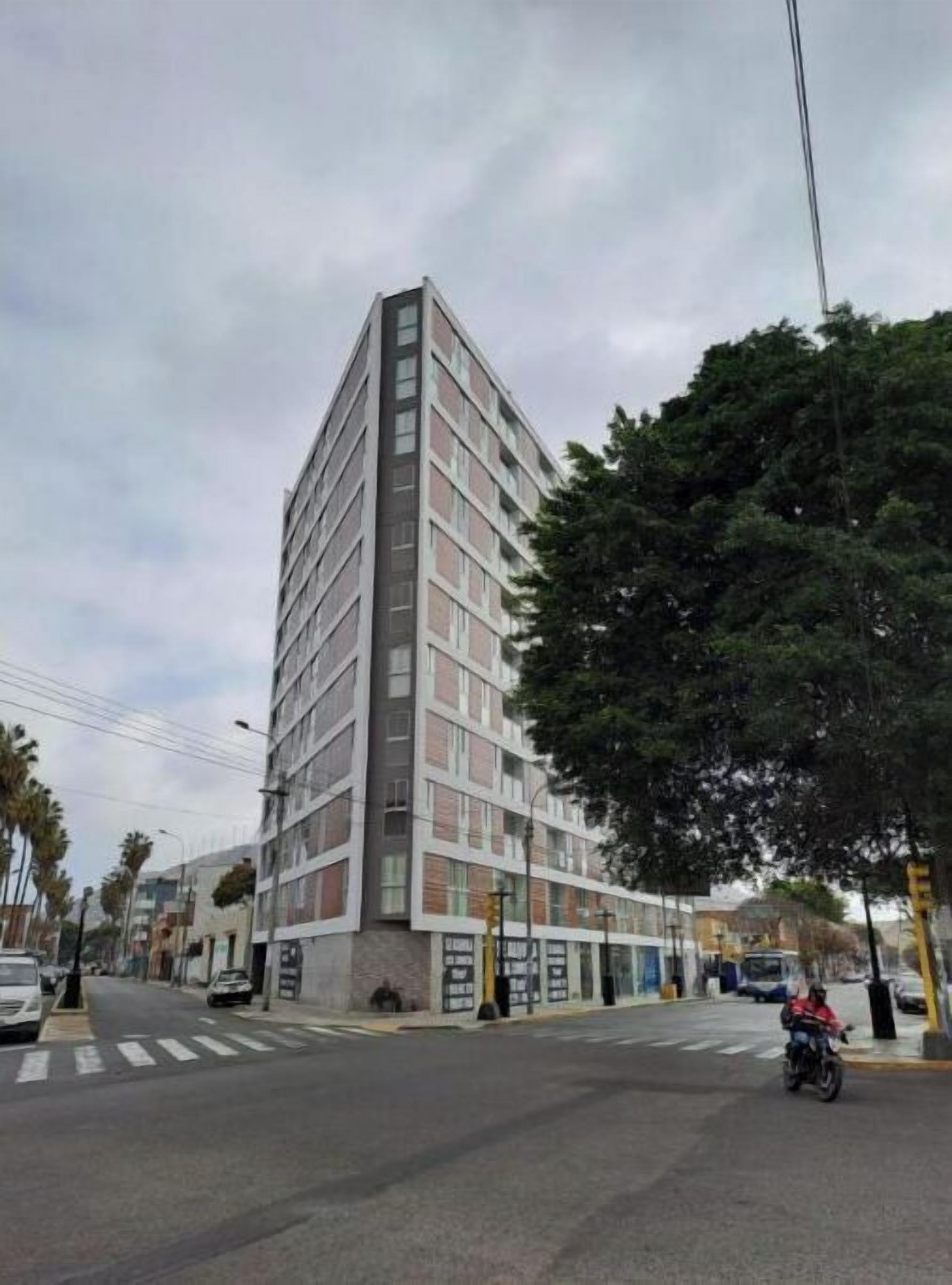 A multi-story building with a modern architectural design, featuring a prominent corner entrance and a series of windows.