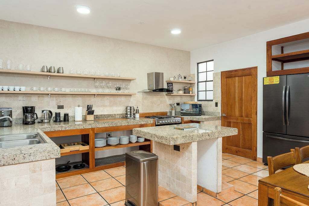 Una cocina compacta con estufa integrada, refrigerador y lavaplatos.