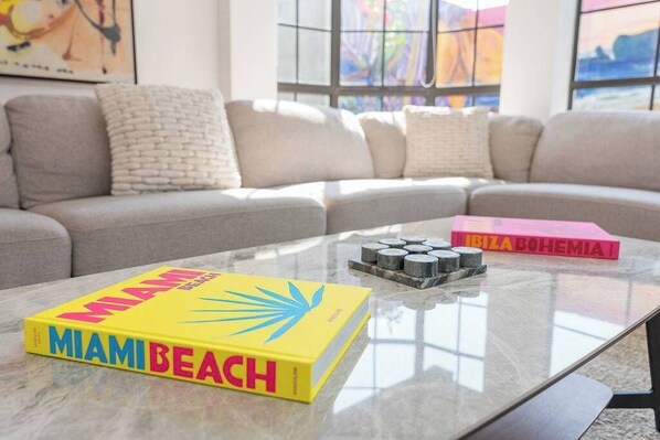A living room with a sofa, a coffee table, and books.