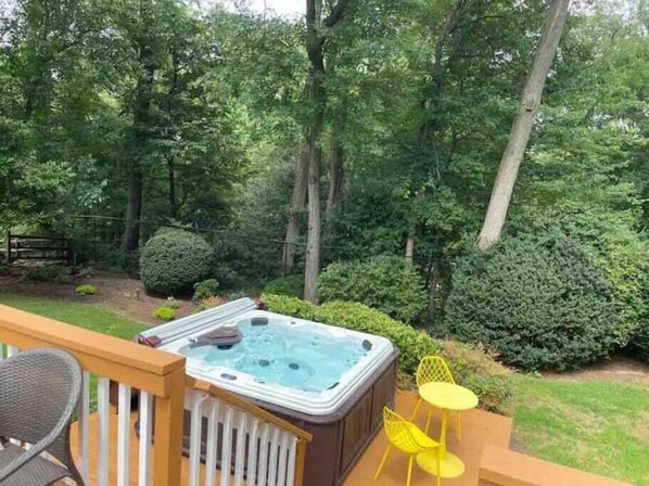 A hot tub on a deck with a view of a forest. - Lux Family Xcape with HotTub, Fireplace, Deck, BBQ (Silver Spring)