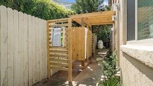 Une pergola en bois avec un fil à linge dans un jardin.