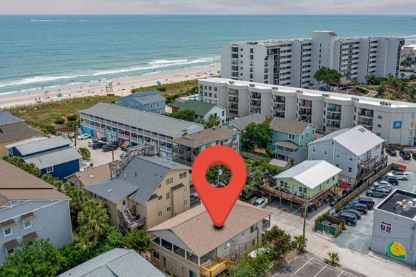 Zona residencial costera con playa, edificios de varios pisos y un estacionamiento.