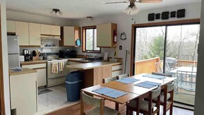 A compact kitchen with a dining area, a ceiling fan, and a view of the outdoors. - Lake Harmony, 4BR, Lake Access, Kayak, Woods, Air Hockey, New Water Treat System (Lake Harmony)