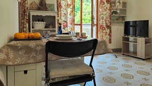 A dining area with a table set for two, a clock on the wall, and a television in the corner. - Carminati 156 by Tempovacanza (Marina di Andora)