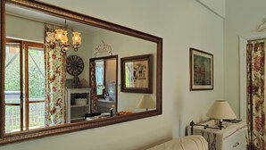 A room with a large mirror, a sofa, a lamp, and a small table with a decorative item. - Carminati 156 by Tempovacanza (Marina di Andora)