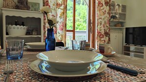 A dining table with a white bowl, blue glass, and a vase with a white flower. - Carminati 156 by Tempovacanza (Marina di Andora)