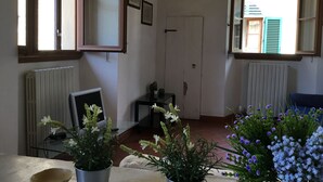A room with a window, radiator, and a small table with a potted plant.